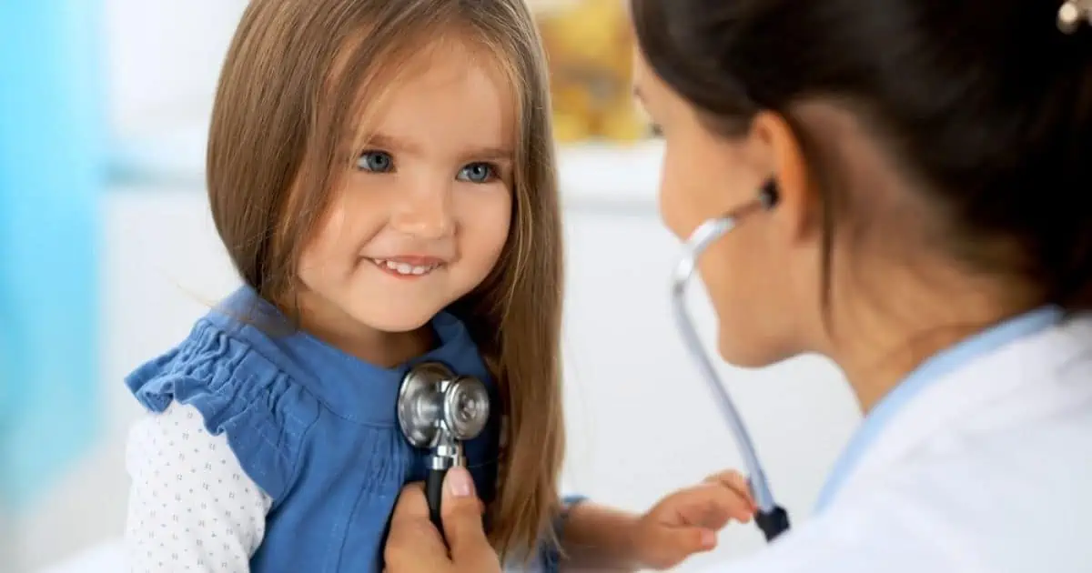 doctor using  a stethescope to listen to a young girl's chest